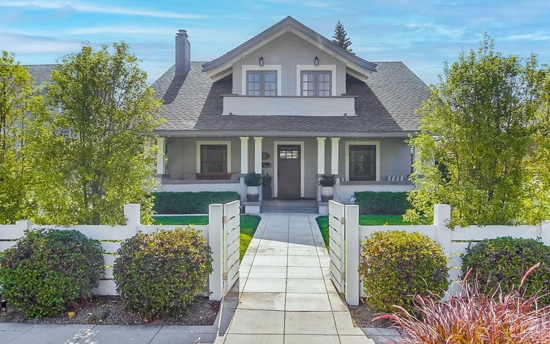 Restored grey Craftsman vacation rental in South Park, San Diego, with a white picket fence and walkway to the front porch