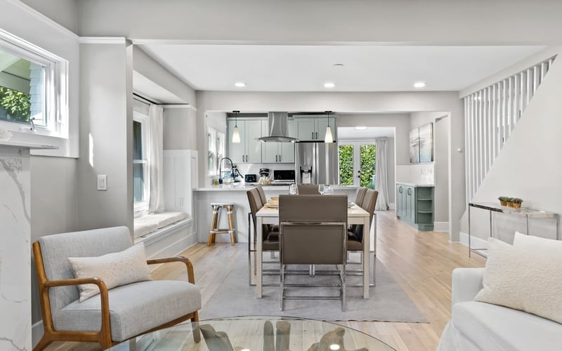 Open-plan living room looking through to the dining table and kitchen, with a staircase along the far wall